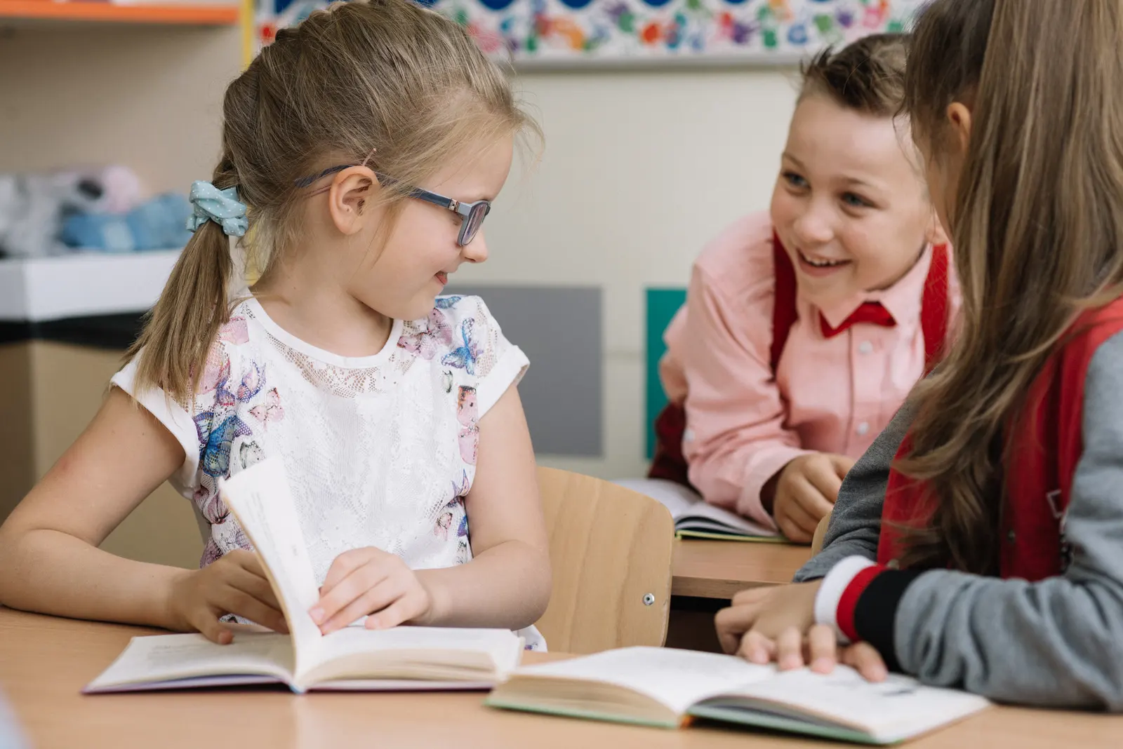 Schoolchildren reading books together in a classroom
